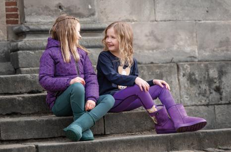 Kinder sitzen auf einer Steintreppe